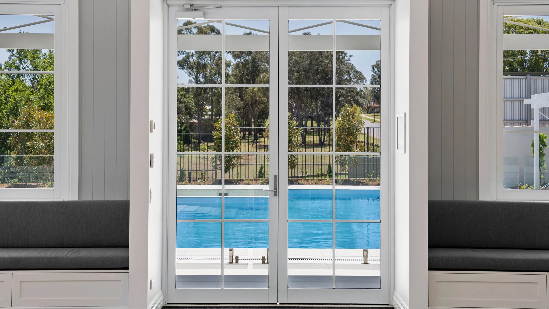 White Aluminium Hinged Doors with designer bars and a self closing mechanism